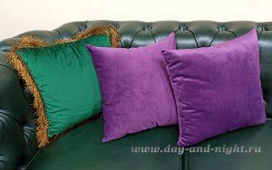 Декоративные подушки из бархата на диване крупным планом.