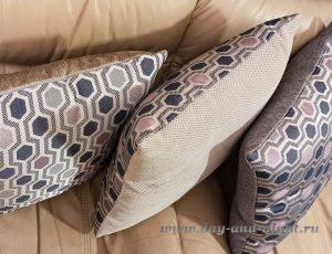 Декоративные подушки с узором на диване крупным планом.