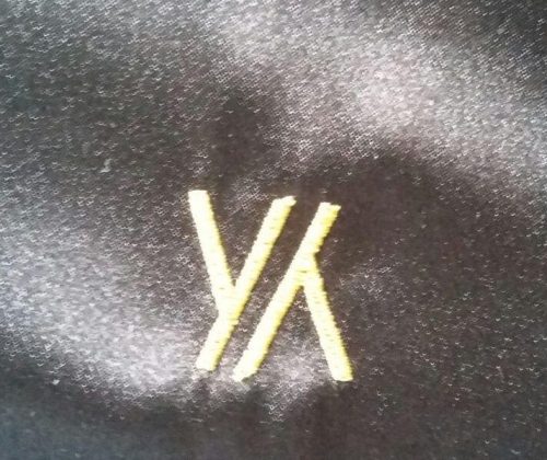 Вышивка логотипа YY крупным планом.